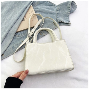 Vue détaillée du sac à main blanc minimaliste avec texture froissée et bandoulière