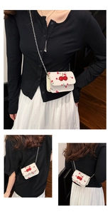 Close-up of small white cherry print bag with 3D sequin cherry detail and chain strap