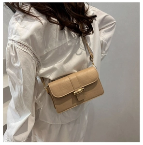 Détail du sac bandoulière beige en similicuir avec texture croco et fermoir bambou doré
