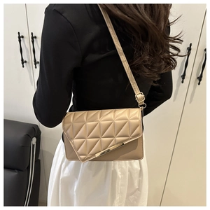 Mannequin portant un sac bandoulière beige matelassé avec détail en métal doré