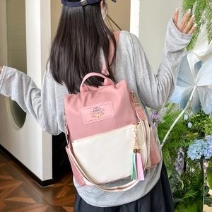 Großer Rucksack in Rosa und Beige mit gestreiften Trägern, getragen von einem Modell