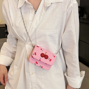 Pink mini saddle bag with red cherry prints and crystal cherry buckle on white shirt