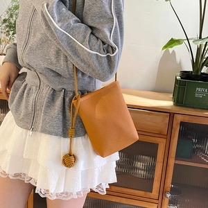 Minimalist orange-brown bucket bag with textured leather and knot detail for women
