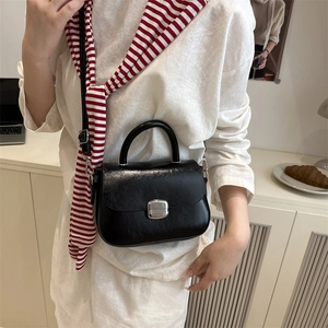 Minimalist black leather square handbag with silver buckle and adjustable shoulder strap