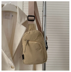 Détail du sac de poitrine en nylon kaki avec compartiments zippés et sangle