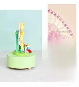 Detail of mint green wooden ferris wheel music box featuring rotating colorful cabins