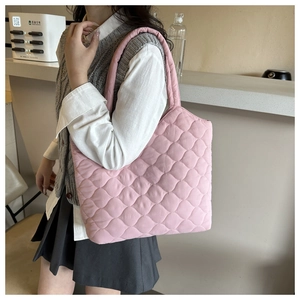 Detailed view of pink quilted tote bag showing padded texture and wavy stitch pattern