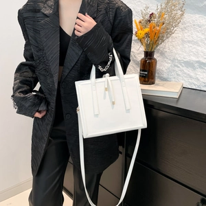 Chic white square crossbody bag with gold metal tips and minimalist leather design