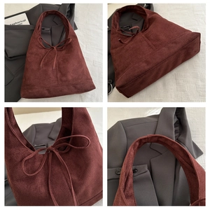 Detail view of burgundy faux suede tote bag with tie-knot bow and premium stitching