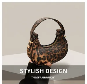 Detailansicht der Mondsichel-Handtasche mit Leopardenmuster und goldenen Beschlägen
