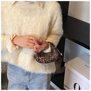 Schicke Mini-Halbmondtasche mit Leopardenmuster kombiniert mit einem flauschigen Pullover