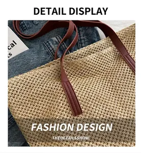 Detail of red-brown leather handles and woven texture on a beige straw tote bag