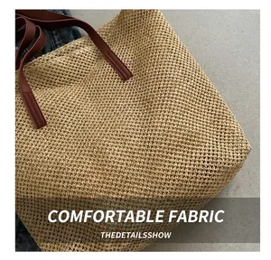 Close-up of straw woven tote bag with premium brown PU leather handles on white linen