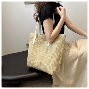 Large woven straw tote bag with white leather straps for casual summer beach vacation