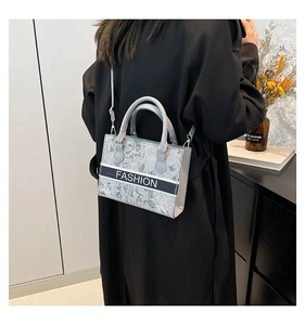 Vue détaillée du tissu jacquard gris et de l'inscription Fashion sur le sac cabas chic