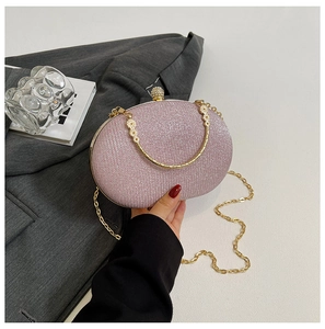 Close-up of pink glitter evening bag with gold floral handle and pearl clasp