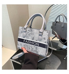 Détail du cabas en jacquard bleu-gris avec texte FASHION blanc et poignée supérieure