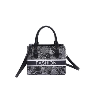Large black and white patterned tote bag with FASHION text and leather handles