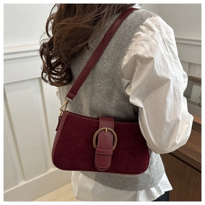 Détail du sac à bandoulière en daim bordeaux avec une boucle dorée vintage demi-cercle