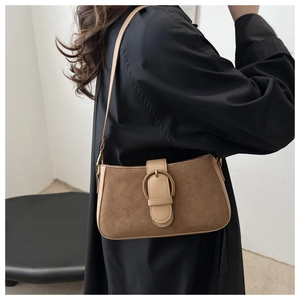 Detailed close-up of retro matte underarm bag with gold horseshoe buckle on leather strap