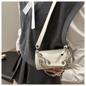 Détail du sac bandoulière blanc cylindrique en cuir avec une chaîne en métal argenté