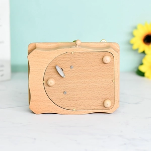 Bottom view of wooden music box with metal clockwork winding key and natural wood texture