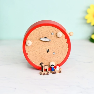 Vue du dessous de la boîte à musique carrousel en bois rouge avec clé de remontage