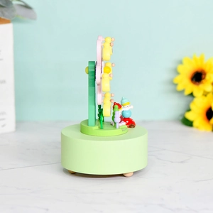 Handcrafted wooden Ferris wheel music box in light green with rotating carousel figures