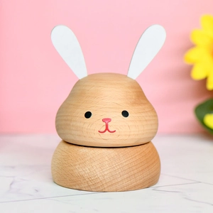 Creative wooden rabbit music box with natural beech texture on a pink background