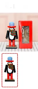 Detailed view of 16.5cm penguin nutcracker ornament with red top hat and gift box packaging