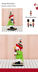 Detail of wooden snowman nutcracker in green with striped knit hat holding a gift box