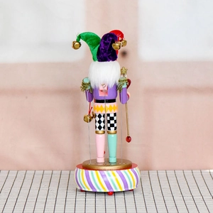Handcrafted wooden nutcracker jester music box with colorful hat and striped round base