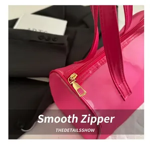 Close-up of smooth golden metal zipper detail on pink mesh portable cosmetic bag