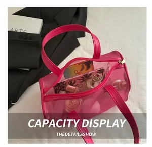 Detail view of large capacity fuchsia mesh tote bag with makeup items and gold zipper