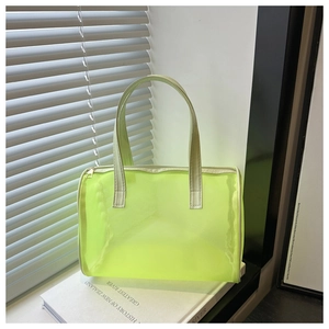 Detail view of neon green mesh handbag with golden zipper and leather handles