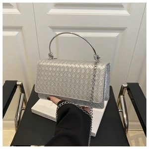 Detail of silver woven hobo bag with metallic finish and semicircular metal handle