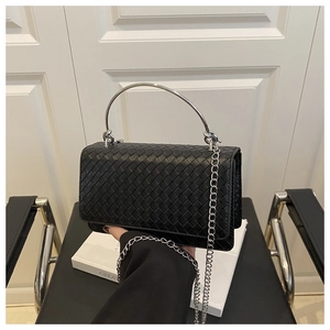 Close-up of black woven leather shoulder bag with silver metal handle and chain strap