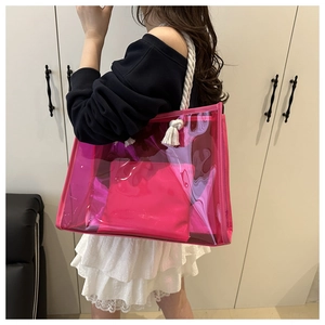 Detailed view of pink PVC tote bag with white cotton rope handles worn by a model