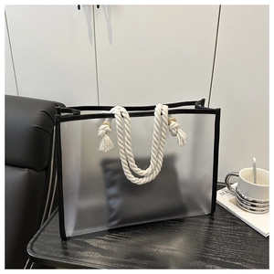 Detail of translucent frosted tote bag with black trim and white braided rope handles
