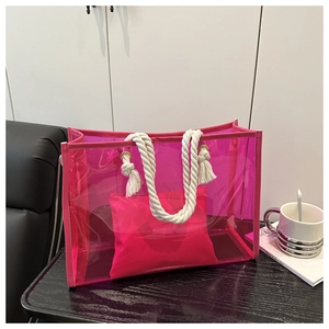 Close-up of pink transparent PVC tote bag with white cotton rope handles and inner pouch