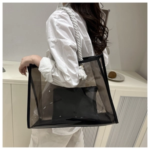 Black transparent PVC tote bag with white rope handles and inner pouch shown on shoulder