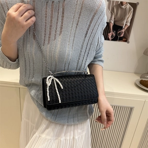 Elegant black woven leather crossbody bag with pearl bow decor and metal chain strap