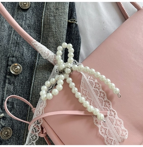 Nahaufnahme der rosa Ledertasche mit weißer Spitze und Perlen-Schleifen-Verzierung