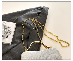 Detail view of elegant silver glitter handbag with gold chain strap and metal handle