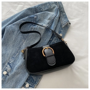 Gros plan d'un sac porté épaule noir mat avec boucle métallique demi-cercle dorée