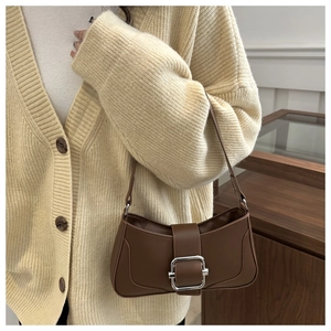 Close-up of brown faux leather baguette bag featuring a silver square buckle detail