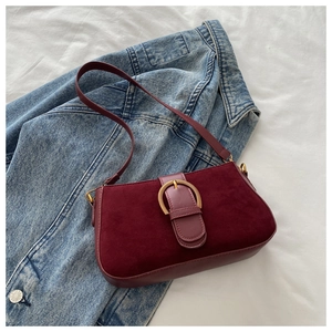 Détail du sac à bandoulière bordeaux vintage avec finition mate et boucle fer à cheval dorée