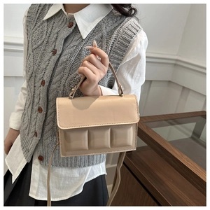 Detail of beige quilted tote bag showing smooth PU leather and gold-tone hardware detail