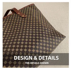 Close-up of vintage tote bag with floral monogram pattern and brown leather handle details