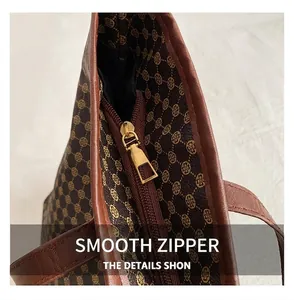 Detailed close-up of the smooth metal zipper and floral print on the brown tote bag
